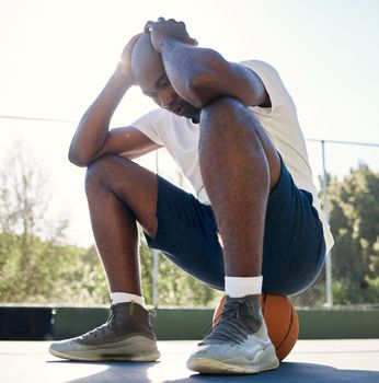 Depression, sport and man on basketball court for fitness outdoors. Stressed black athlete, mental health and tired after wellness workout or exercise training burnout in sports park with ball.