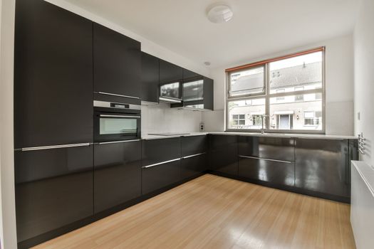 a kitchen with black cabinets and a window