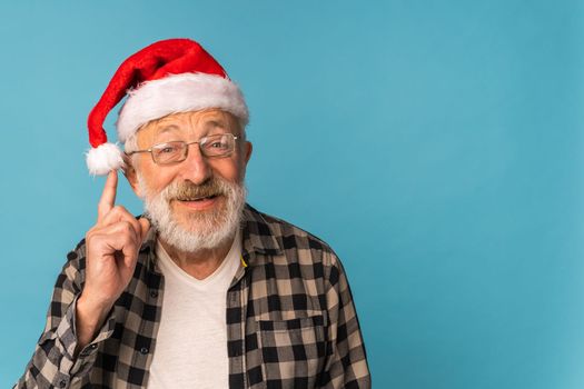 Portrait of happy emotions Santa Claus excited looking at camera on blue background with copy space