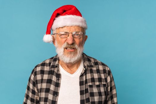 Gloomy Santa Claus portrait against blue background with copy space. Economy crisis and troubles end of year concept