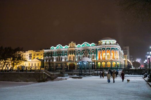 YEKATERINBURG, December 18, 2021: Sevastyanov House also House of Trade Unions in Yekaterinburg in Russia at night and winter season. Its a palace built in the first quarter of XIX century on the banks of the city pond, formed by a dam on the Iset River.