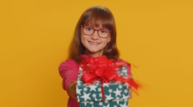 Lovely smiling preteen child girl kid presenting birthday gift box offer wrapped present celebrating