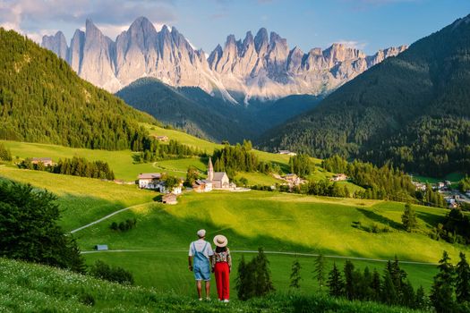 couple viewing the landscape of Santa Maddalena Village in Dolomites Italy, Santa Magdalena village magical Dolomites mountains, Val di Funes valley, Trentino Alto Adige region, South Tyrol, Italy, 