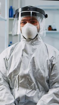 Portrait of experienced scientist man in coverall smiling at camera