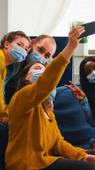 Multiracial friends taking selfie with face masks during covid 19 outbreak