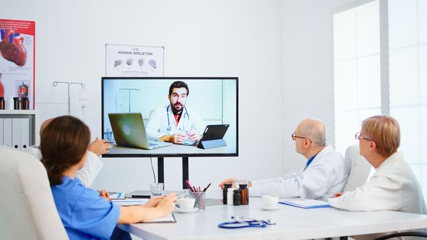 Medical team holding online conference in boardroom