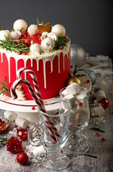 Festive Christmas cake on a rustic wooden stand and holiday decoration. New Year cards and sparklers