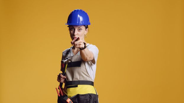 Portrait of engineer holding hammer and pointing at camera