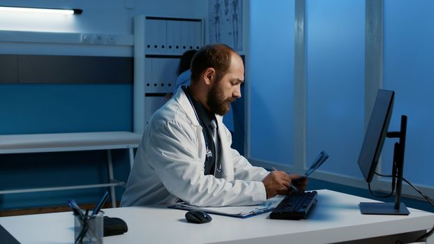 Caucasian general practitioner analyzing patient lungs radiography checking medical expertise