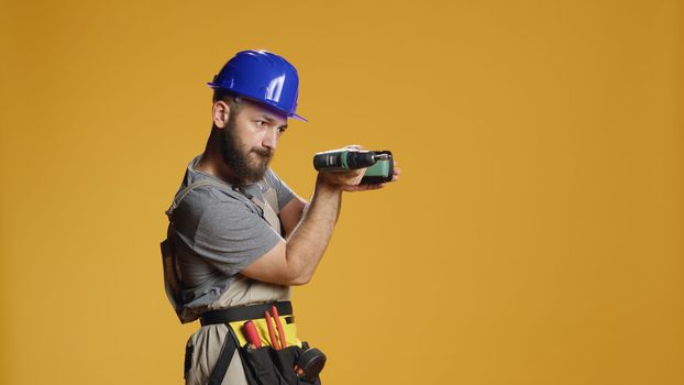 Portrait of repairman builder using electric power drill machine