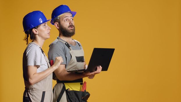 Man and woman contractors using laptop to do rebuilding measurement