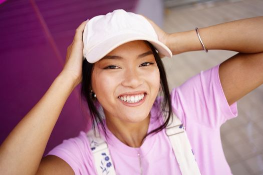 Asian woman touching head and smiling