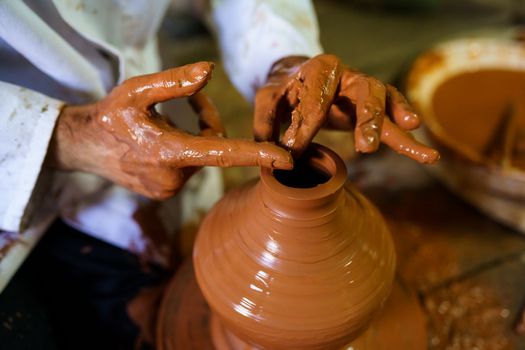 Craftsman moulding a piece of pottery on an Arab potter's wheel.