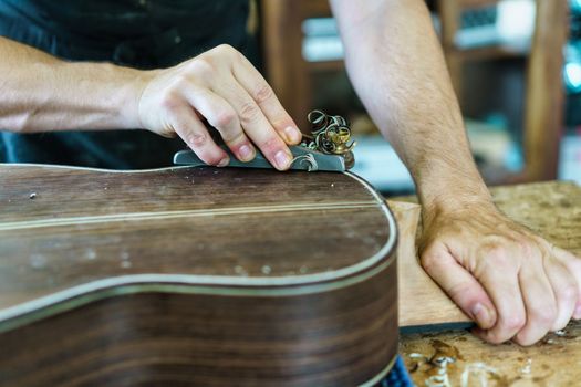 Unrecognizable male luthier crafting Spanish flamenco guitar