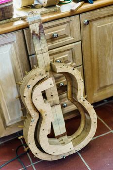 Wooden mould for making Spanish flamenco guitar in luthier workshop.