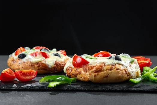 Homemade pizza with vegetables for breakfast on black background with blank space for text