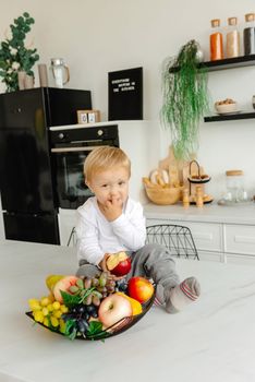 A child picks his nose in the kitchen