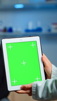 Health care researcher holding and looking at tablet with chroma key