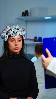 Ill woman listening neurological doctor looking at clipboard