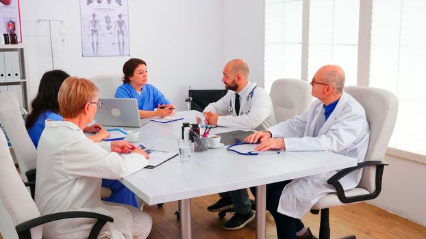 Team of expert doctors having a briefing in hospital conference room