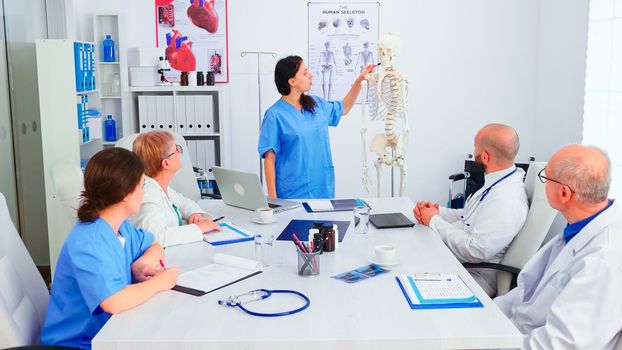 Nurse giving presentation using skeleton model