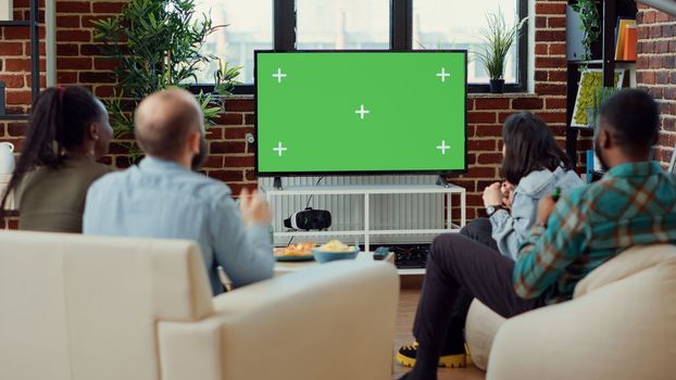 Soccer fans watching football match using greenscreen on television