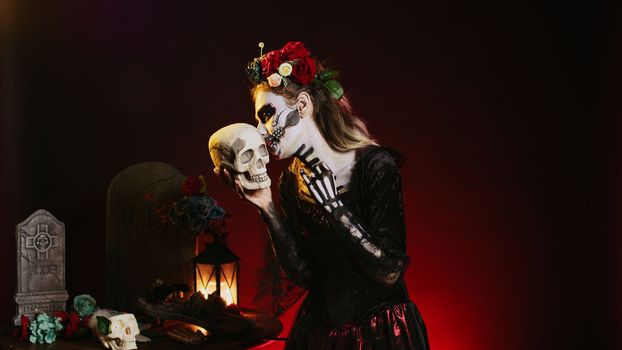 Young scary model posing with skull in studio