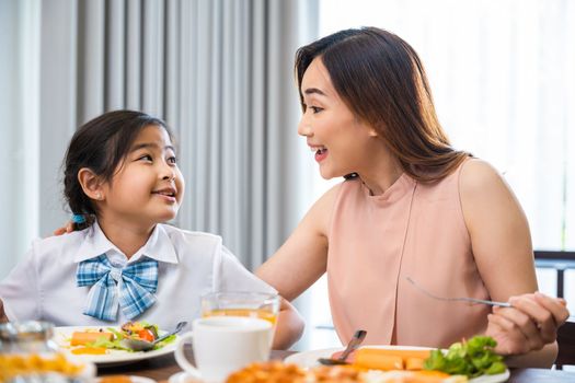 Mom and little preschooler have fun smile eating meal together