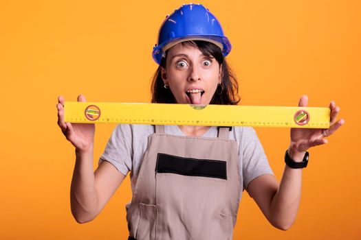 Cheerful construction worker using leveler to check flat walls