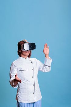 Confident elderly cook wearing virtual reality glasses while preparing culinary recipe