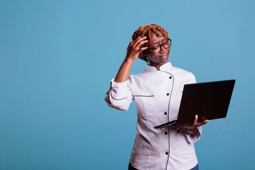 Chef using laptop with confused expression