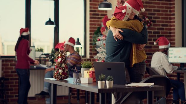 Startup employees celebrating winter holiday in festive office