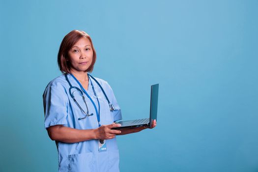 Medical assistant typing medical prescription on laptop computer