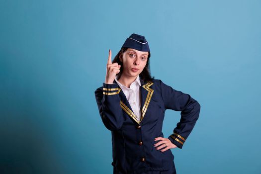 Flight attendant pointing up with index finger