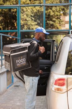 African american courier delivering office food order by car