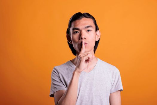 Man showing quiet gesture, silence concept