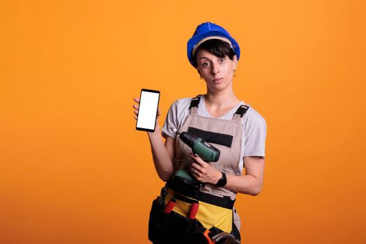 Female contractor pointing drilling gun at empty white screen