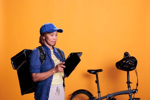 Slide view of cheerful deliverywoman holding tablet computer checking client location