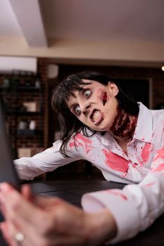 Aggressive woman monster looking at laptop