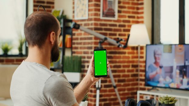 Office worker analyzing smartphone with greenscreen template