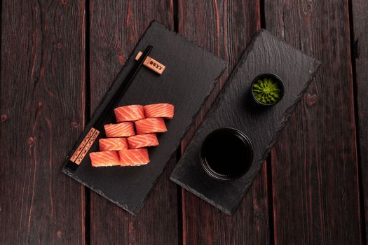 Sushi roll maguro with tuna, smoked eel, avocado, philadelphia cheese on black board top view. Sushi menu. Japanese food.