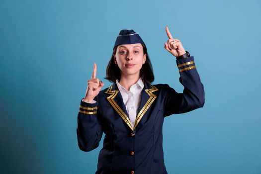 Stewardess pointing up with index fingers