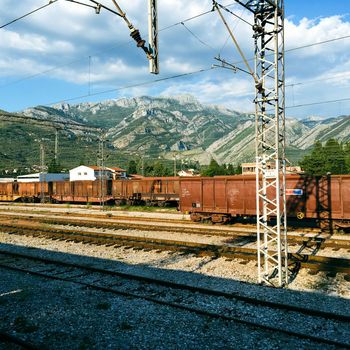 View of a rail yard with mountains in the background and overhead power lines in budvha dubrovnik. High quality photo