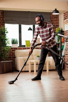 African american man with wireless headset cleaning floor