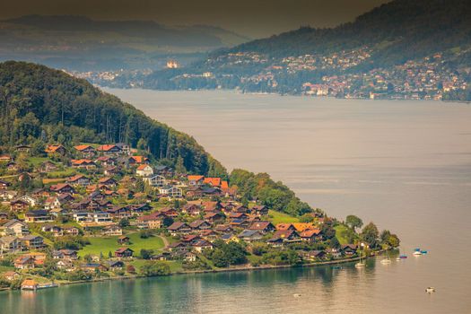 Aerial view of Swiss Alps and Lake Thun with ferry boat at sunset, Interlaken