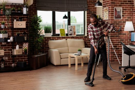 Single African-American male doing house cleaning.