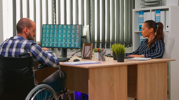 Businessman in wheelchair working in corporate office