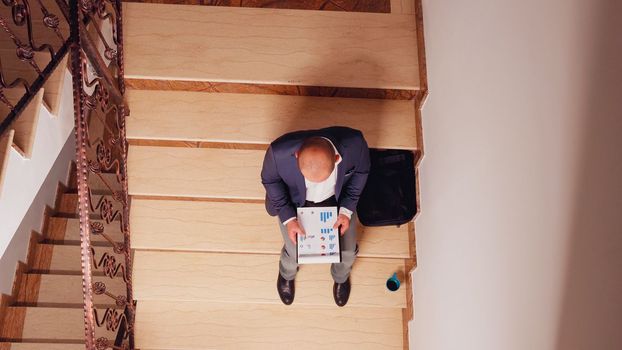 Top view of entrepreneur reading financial statistics from clipboard