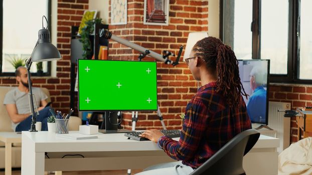 African american freelancer watching computer with greenscreen