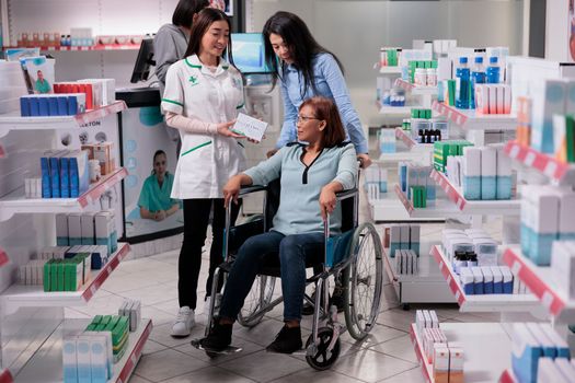 Social worker and wheelchair user in drugstore
